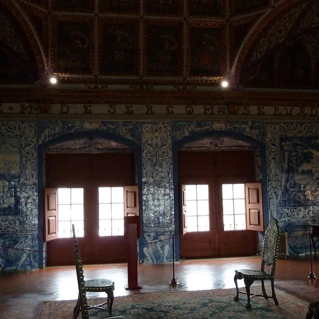 Сине-белые азулежу panels covering the walls of the Coats of Arms Room in the Sintra National Palace, with an inscribed frieze above the doors.